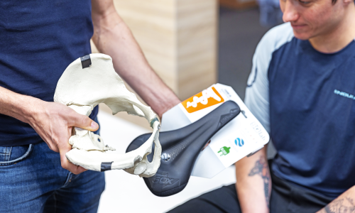 © Fotograf / Theresa Ferstl / Beim Sattel ist entscheidend, ob die Sitzbeinhöcker auf der vorgesehenen Stelle aufliegen – erklärt anhand eines Modells der Beckenknochen. Besuch beim Bikefitter: Radhändler Bernhard Kohl erklärt, wie es sich "richtig" am Bike sitzt